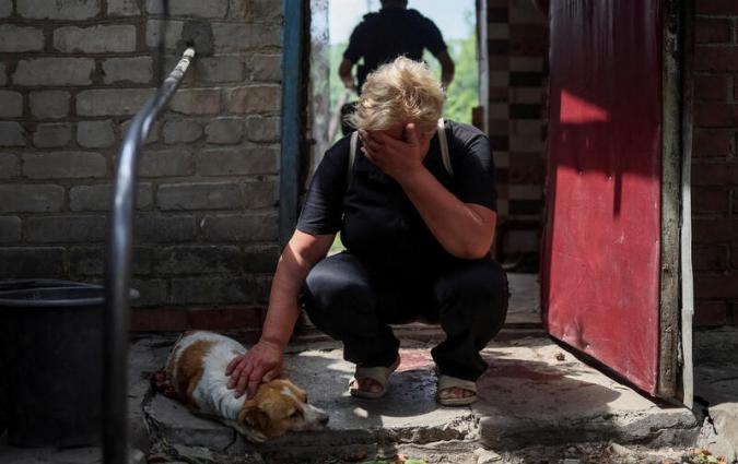 Lena, 58, reacts near her critically wounded dog Hera, during a Russian military strike, as Russia's attack on Ukraine continues, in Kostiantynivka, Ukraine July 9, 2022. REUTERS/Gleb Garanich TPX IMAGES OF THE DAY
