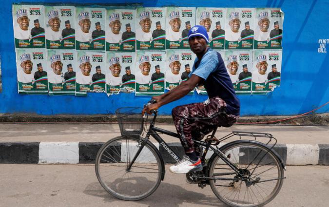 A man rides a bicycle past electoral campaign posters in Lagos, Nigeria. REUTERS/Temilade Adelaja