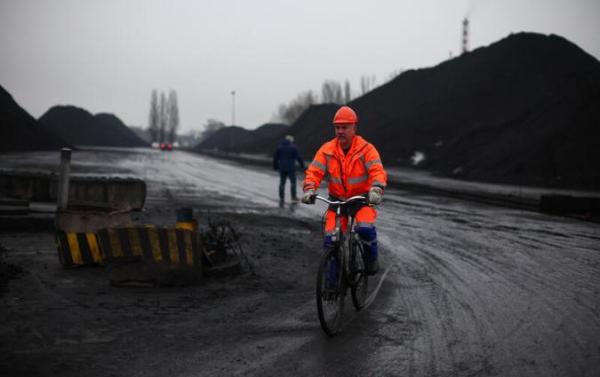 Image of man riding bicylce at a coal storage area in Gdansk