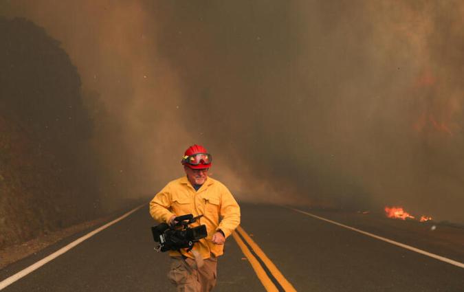 A NBC News journalist takes cover from an approaching fire in California in 2020. REUTERS/Adrees Latif
