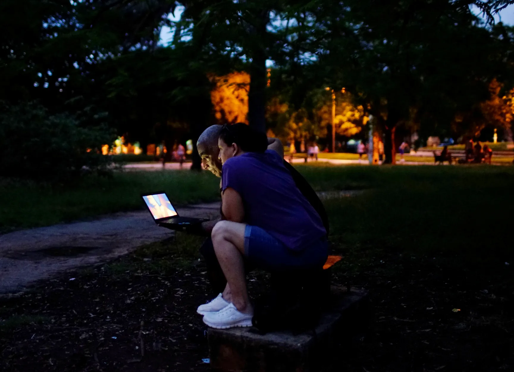 A couple use a computer at in a park in Havana, Cuba, October 19, 2017. Picture taken on October 19, 2017. REUTERS/Alexandre Meneghini