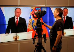 Russian president Vladimir Putin on a TV screen