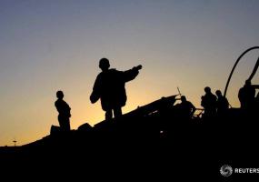 Palestinian children walk on the ruins of the destroyed house