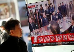 A man watches a TV broadcasting a news report Korea