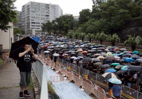 Man takes photo in front of umbrella protest