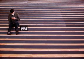 Man sits looking at mobile phone (REUTERS/Kim Hong-Ji)
