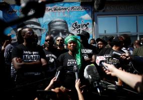 Assa Traore, sister of Adama Traore, who died in a 2016 police operation, talks to journalists in front of a fresco in memory of her brother and George Floyd in Stains, France. REUTERS/Benoit Tessier