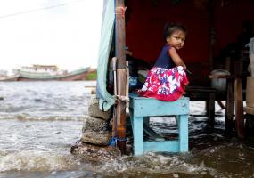 Shaqueena Dwi Arsyilla, 2, sits on a bench at Kali Adem port, which is impacted by high tides due to the rising sea level and land subsidence, north of Jakarta, Indonesia November 20, 2020. REUTERS/Willy Kurniawan