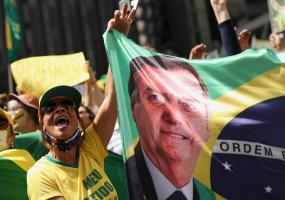 A supporter of President Jair Bolsonaro holds a banner with his image