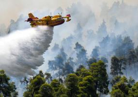 A firefighting airplane makes a water drop
