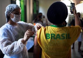 A health worker administers a dose of a COVID-19 vaccine in Rio de Janeiro, Brazil. REUTERS/Lucas Landau