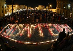 People light candles in the shape of a sign which reads "Solidarity" in protest against coronavirus disease (COVID-19) deniers at Odeonsplatz in Munich, Germany February 10, 2022. Picture taken with a a fish-eye lens. REUTERS/Lukas Barth