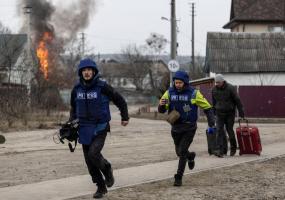 Journalists run for cover after heavy shelling on the only escape route used by locals, while Russian troops advance towards the capital, in Irpin, near Kyiv, Ukraine March 6, 2022. REUTERS/Carlos Barria