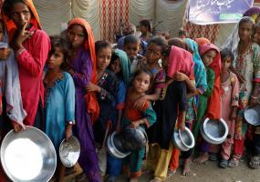 Flood victims gather to receive food handout in a camp, following the floods in Sehwan, Pakistan. REUTERS/Akhtar Soomro