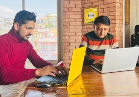 Journalist Himal Poudel and Deepak Adhikari, editor of NepalCheck (left), work at an office in Kathmandu. 