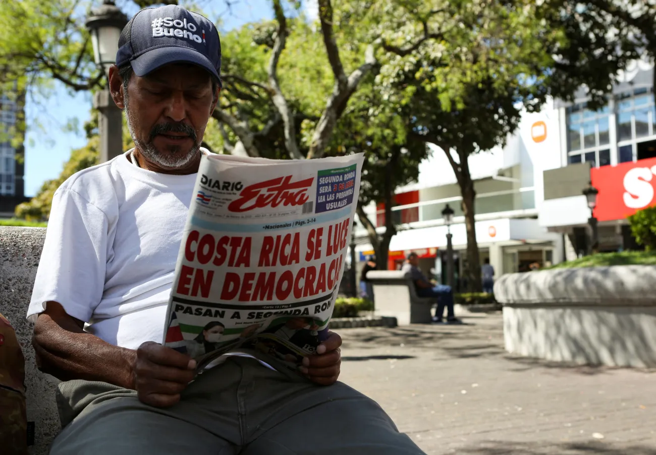 A man reads a newspaper with a cover story on the preliminary results of Costa Rica's first-round presidential election, in San Jose, Costa Rica, February 7, 2022. REUTERS/Mayela Lopez