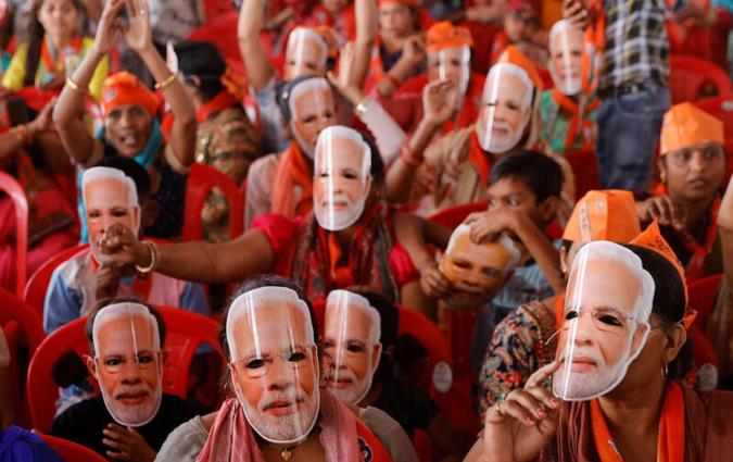 Supporters of India's Prime Minister Narendra Modi wear masks of his face, as they attend an election campaign rally in Meerut, India, March 31, 2024. REUTERS/Anushree Fadnavis